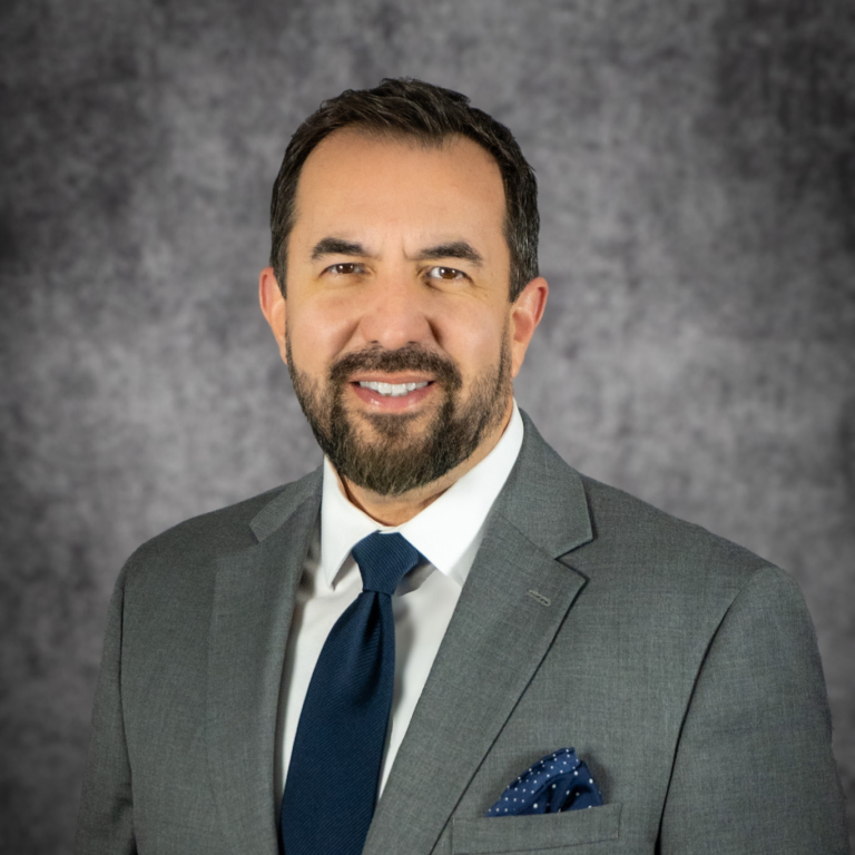 Smiling man in gray suit and navy tie