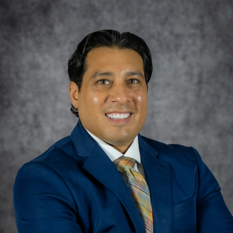Smiling person in blue suit and tie