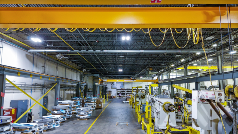 Long factory aisle with cranes and equipment