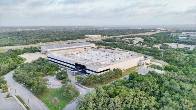 Wide aerial of commercial campus and forest