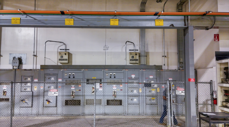 Fence-protected electrical switchgear and conduit